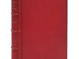 un livre rouge à la couverture rouge posé sur une surface blanche