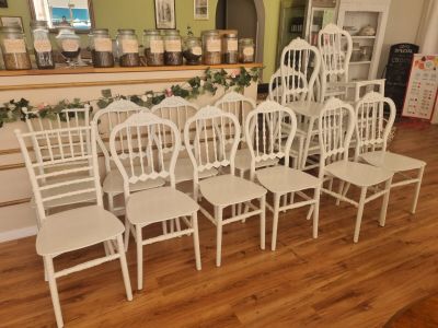 Plusieurs chaises blanches sont alignées en rang devant un comptoir.