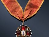 a close up of a medal with a red ribbon around it