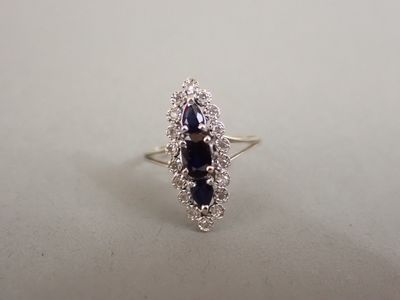 un gros plan d'une bague sertie de diamants et de saphirs posée sur une table