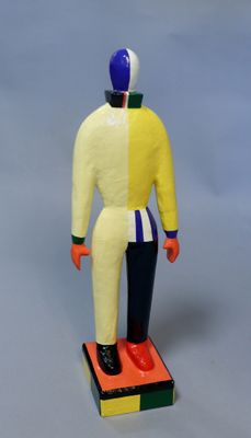 figurine représentant un homme en costume jaune et bleu, debout sur un bloc