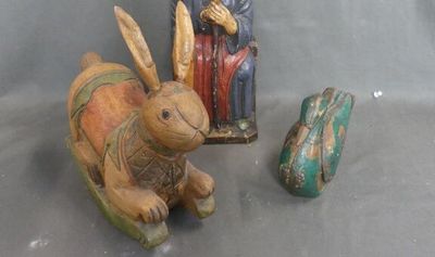une statue représentant un lapin assis à côté d'une figurine représentant un homme