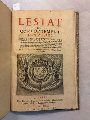 an old book with a picture of a coat of arms on it