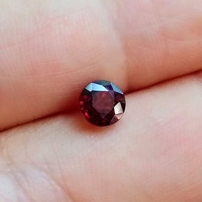 quelqu'un tient une pierre de grenat rouge dans la main