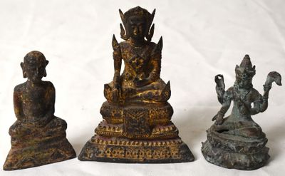 trois statues de Bouddha en bronze, assises sur un socle blanc