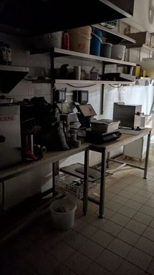 une cuisine avec beaucoup de désordre sur le comptoir