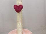 a cat scratching post with a red heart on top of it