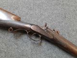 the rifle is laying on the floor next to the wall