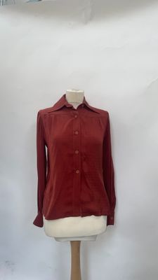 a mannequin with a red shirt on a white mannequin stand