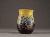 a yellow vase sitting on a table on a gray surface
