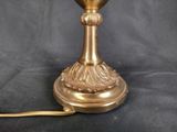 a gold lamp that is sitting on a black table