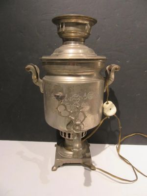a silver urn with a bird on it on a table