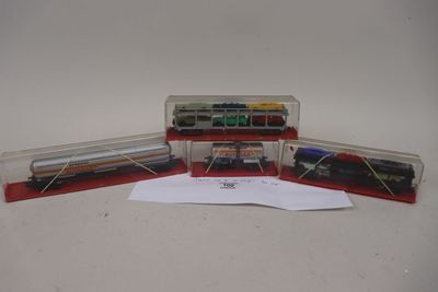 trois petits trains sont posés dans une boîte transparente sur une table