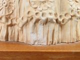 a close up of a sculpture on a wooden shelf