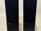 deux enceintes noires posées sur une surface blanche
