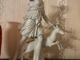 a statue of a woman and a dog on a table