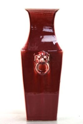 un vase rouge orné d'un anneau