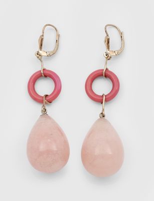 une paire de boucles d'oreilles roses et dorées sur fond blanc