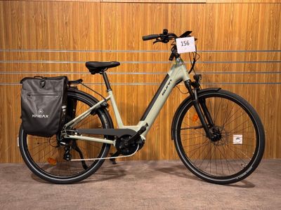 un vélo garé dans un garage, avec un sac à l'arrière