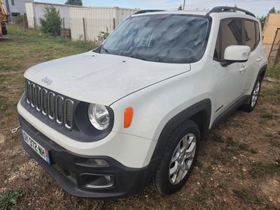 La jeep blanche est garée sur la pelouse dans la cour.