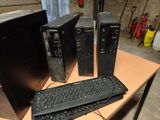 three computers and a keyboard on a table