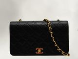 a black chanel bag with a gold chain hanging from it