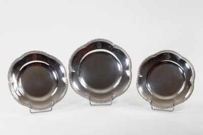 three silver plated dishes on stands on a white surface