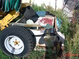 un tracteur qui est garé dans l'herbe près d'un bâtiment