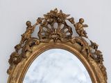 a gold mirror with angels and cherenshes on it