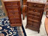 two wooden tables with marble tops in a room