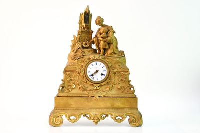 une horloge dorée posée sur une table blanche