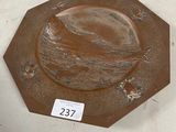 une assiette marron ornée d'un oiseau, posée sur une table