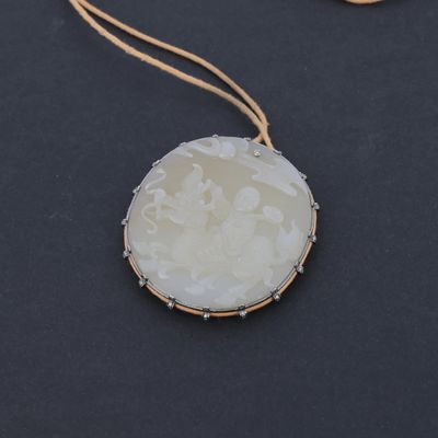 un gros plan d'un collier posé sur une surface noire, avec une chaîne dorée