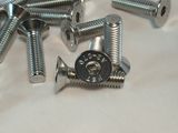 many screws and nuts laying on a white surface