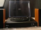 a record player sitting on top of a table next to speakers