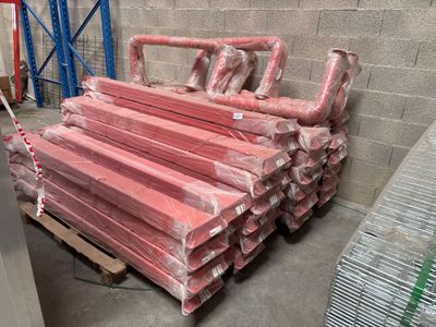 une pile de tuyaux rouges posée sur une palette dans un entrepôt