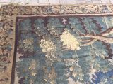 un tapis posé à même le sol, sur lequel est représenté un arbre