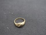 gros plan d'une bague en or sur une surface noire