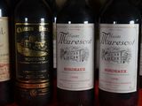 several bottles of wine are lined up on a red table