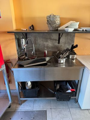 une petite cuisine équipée d'une cuisinière, d'un évier et d'un réfrigérateur