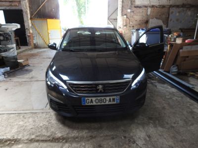 a black car parked in a garage with a door open