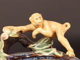 a figurine of a monkey sitting on a tree branch