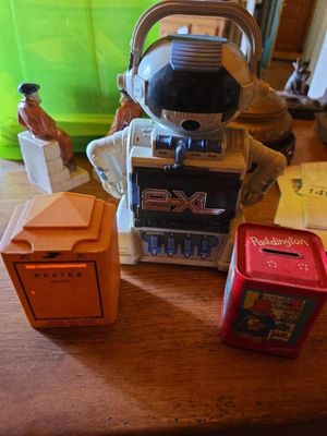 a toy astronaut sitting on top of a table next to a box of cigarettes
