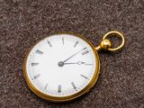 une montre de poche en or avec des chiffres romains