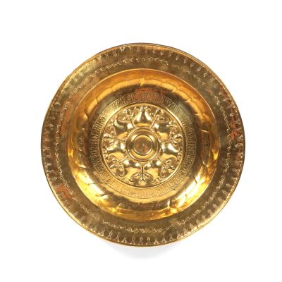 une assiette en or ornée d'un motif sur un fond blanc