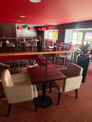 tables and chairs in a restaurant with red walls and a red ceiling