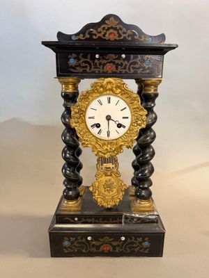 a black and gold clock sitting on top of a table