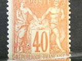 un timbre orange et noir sur lequel figure l'image d'une femme