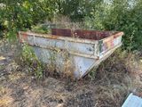 a rusted out boat sitting in the middle of a field