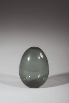 a green glass ball sitting on a white surface